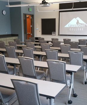 photo of 's Pine Nobel classroom with tables, chairs, and a projector screen